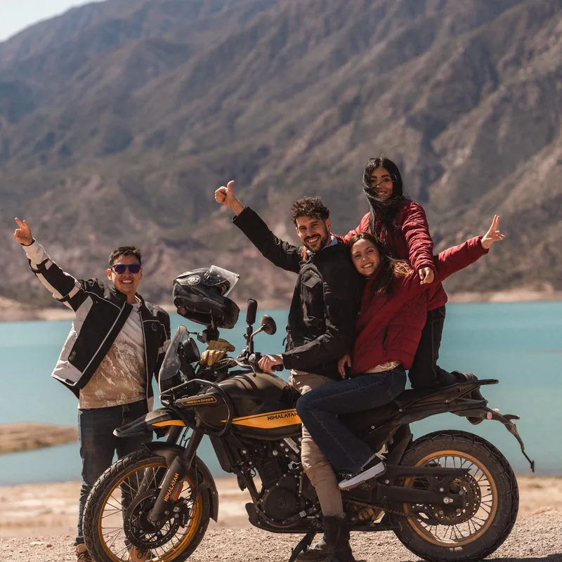 Travelers with a Royal Enfield Himalayan by the Potrerillos reservoir